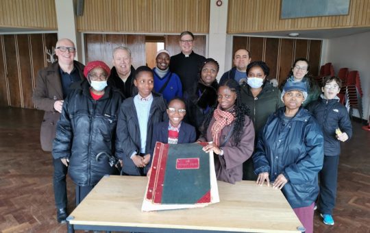 St Paul's Parishioners gather around scrap book